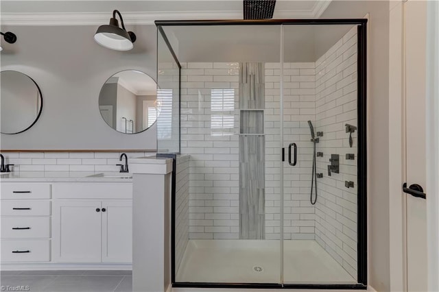 bathroom featuring tile patterned floors, crown molding, a shower stall, and vanity