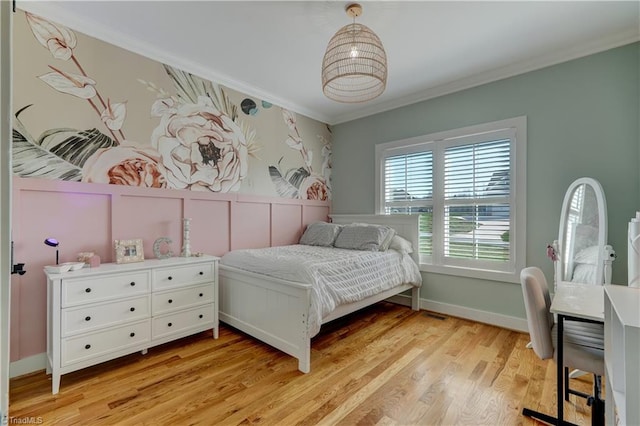 bedroom featuring ornamental molding, light wood-style flooring, and baseboards