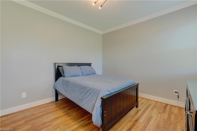 bedroom with baseboards, ornamental molding, and light wood-style floors