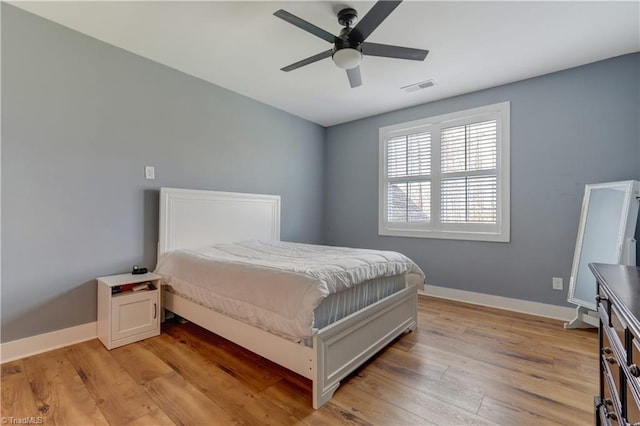 bedroom featuring light wood-style floors, baseboards, and a ceiling fan