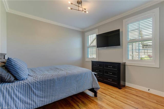 bedroom with crown molding, light wood finished floors, baseboards, and a chandelier