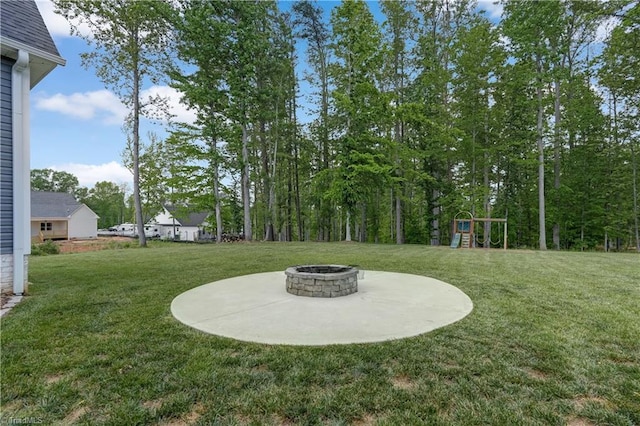 view of grassy yard with an outdoor fire pit