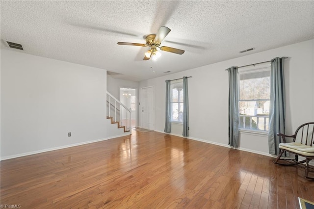 unfurnished room featuring wood-type flooring, a textured ceiling, and ceiling fan