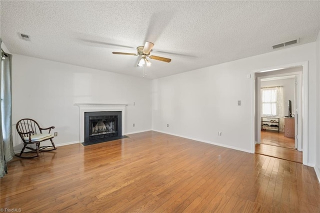 unfurnished living room featuring hardwood / wood-style floors, a textured ceiling, and ceiling fan