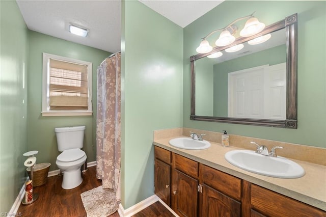 bathroom with hardwood / wood-style flooring, vanity, and toilet