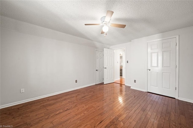 unfurnished bedroom with ceiling fan, dark hardwood / wood-style floors, and a textured ceiling