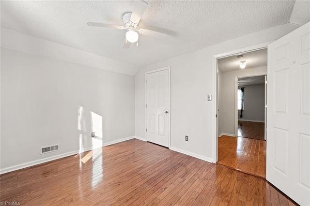 spare room featuring ceiling fan, hardwood / wood-style floors, and a textured ceiling