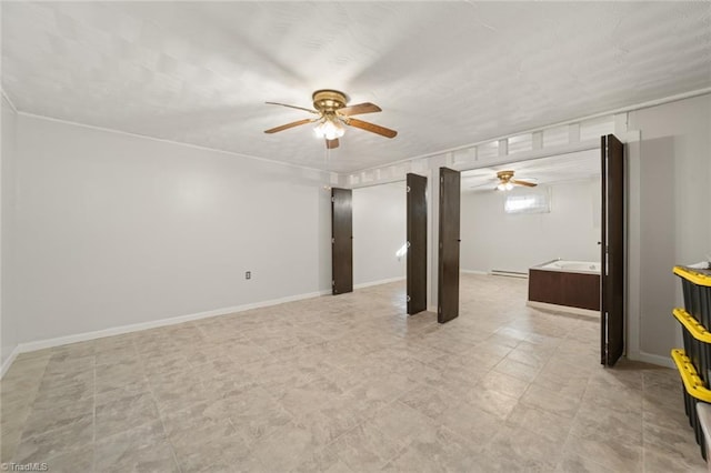 basement with ceiling fan and baseboard heating