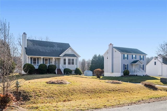 view of front of property featuring a storage shed, covered porch, and a front yard