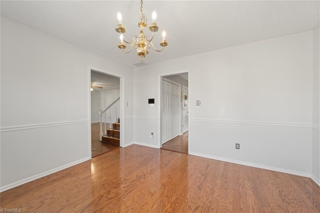 spare room featuring hardwood / wood-style flooring and a chandelier