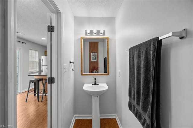1948 Ray Alexander Dr, Greensboro, NC 27410 - bathroom featuring a textured ceiling, wood finished floors, and baseboards