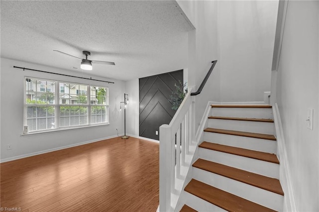 1948 Ray Alexander Dr, Greensboro, NC 27410 - staircase featuring wood finished floors, a textured ceiling, a ceiling fan, and baseboards