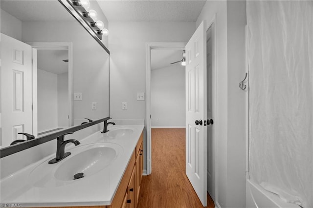 1948 Ray Alexander Dr, Greensboro, NC 27410 - full bath with wood finished floors, double vanity, and a textured ceiling