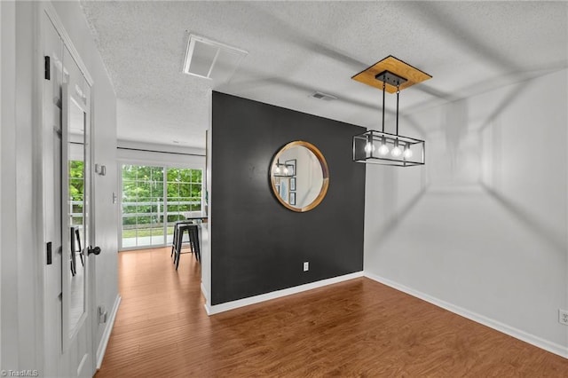 1948 Ray Alexander Dr, Greensboro, NC 27410 - unfurnished dining area featuring a textured ceiling, wood finished floors, and baseboards