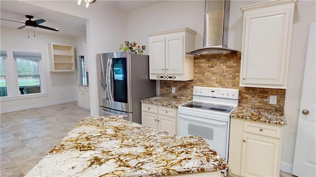 kitchen with stainless steel refrigerator with ice dispenser, light stone counters, wall chimney range hood, a ceiling fan, and white electric range