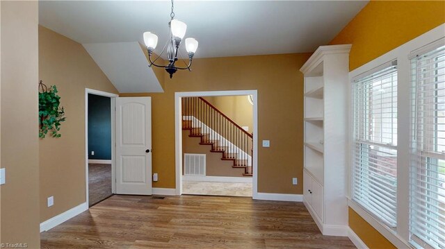 interior space with stairs, visible vents, wood finished floors, and an inviting chandelier