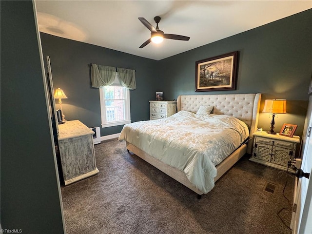 bedroom featuring baseboards, visible vents, dark carpet, and a ceiling fan