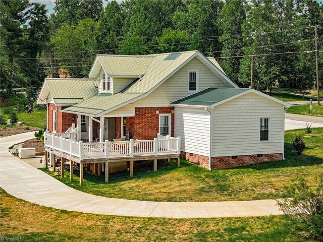 back of property with crawl space, metal roof, a yard, and a wooden deck
