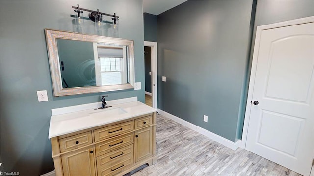 bathroom featuring baseboards, wood finished floors, and vanity