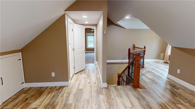 additional living space featuring baseboards, lofted ceiling, and wood finished floors