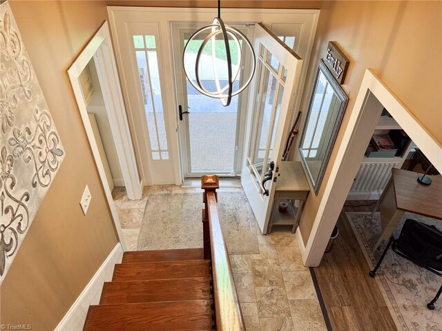foyer entrance with stone finish flooring and baseboards