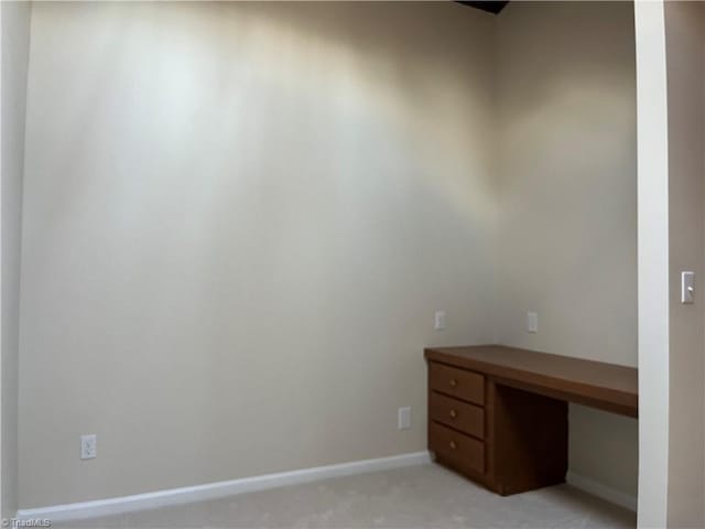 unfurnished office featuring light colored carpet and baseboards