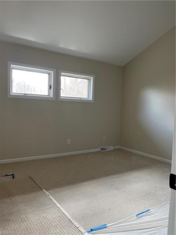 carpeted empty room with visible vents and baseboards