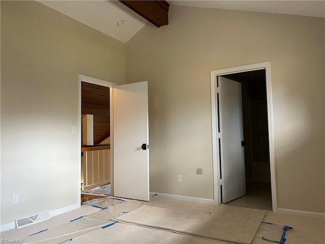 unfurnished bedroom featuring vaulted ceiling with beams, baseboards, visible vents, and light colored carpet