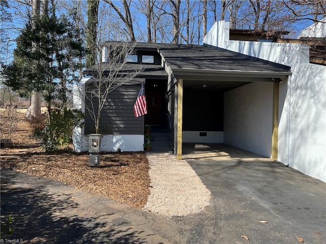 view of parking / parking lot featuring aphalt driveway and an attached carport