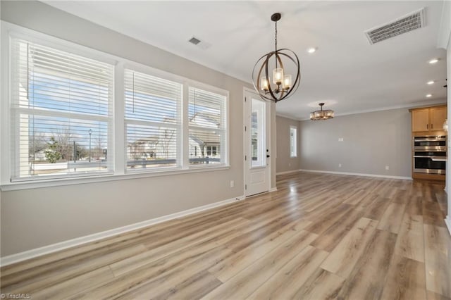 unfurnished living room featuring baseboards, light wood-type flooring, visible vents, and a notable chandelier