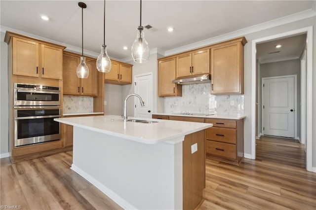 kitchen with stainless steel double oven, black electric cooktop, under cabinet range hood, a sink, and crown molding