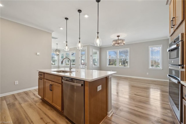 kitchen with a sink, light wood-type flooring, light countertops, and dishwasher