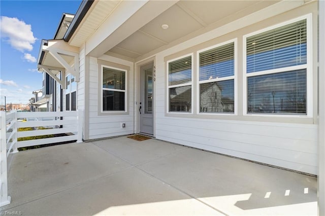 property entrance with a patio area and fence