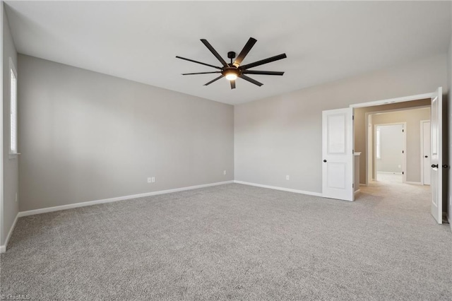 empty room with ceiling fan, carpet floors, and baseboards