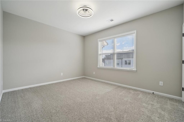 empty room featuring baseboards, visible vents, and carpet flooring