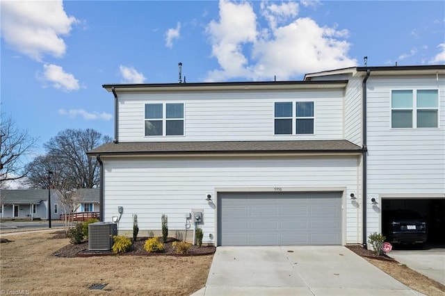 view of front facade featuring concrete driveway, central AC unit, and an attached garage