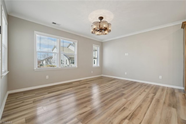 empty room with ornamental molding, visible vents, and light wood-style flooring