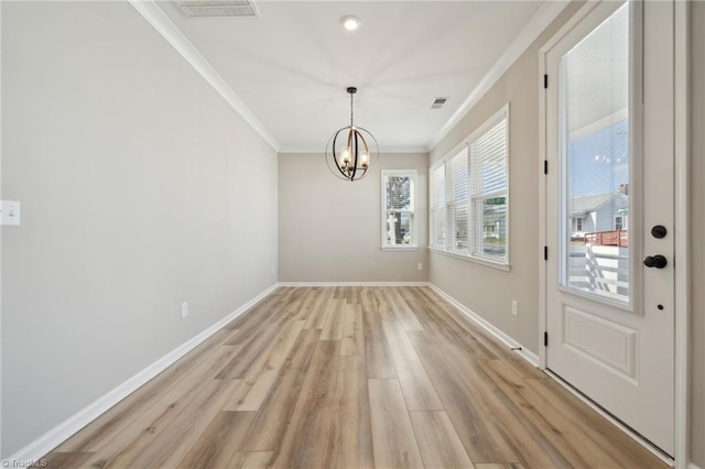 unfurnished dining area featuring ornamental molding, light wood-type flooring, visible vents, and baseboards