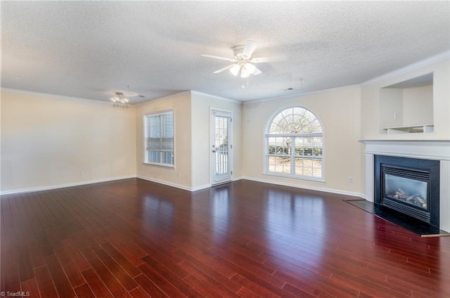 unfurnished living room featuring dark wood-type flooring, ceiling fan, ornamental molding, and a textured ceiling