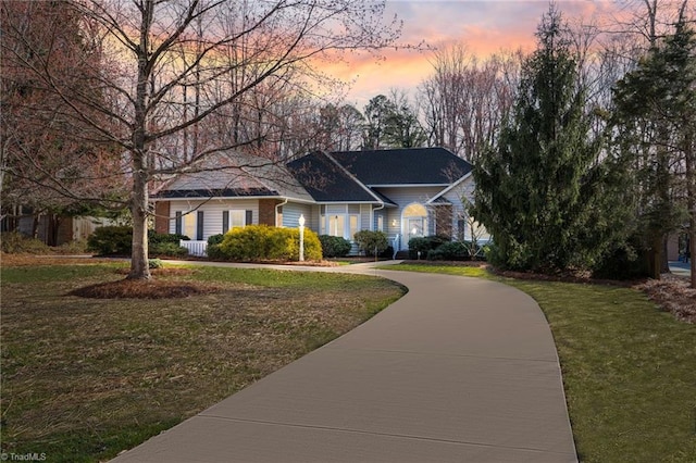 view of front of home with a front yard and concrete driveway