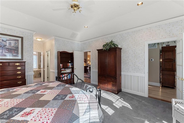 bedroom with a wainscoted wall, ornamental molding, carpet floors, wallpapered walls, and vaulted ceiling