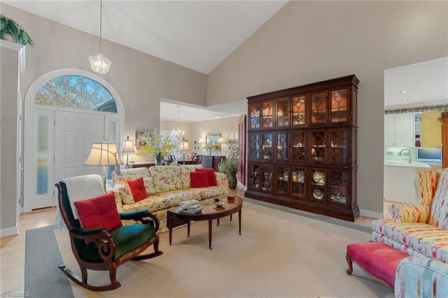 living room with high vaulted ceiling and an inviting chandelier