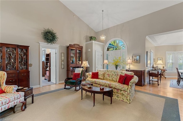 living room featuring light wood-style flooring, high vaulted ceiling, and baseboards