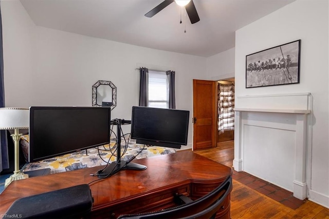 office area with dark wood-type flooring and ceiling fan