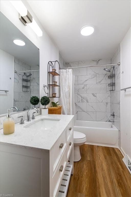 full bathroom with vanity, toilet, hardwood / wood-style floors, and shower / bath combo with shower curtain