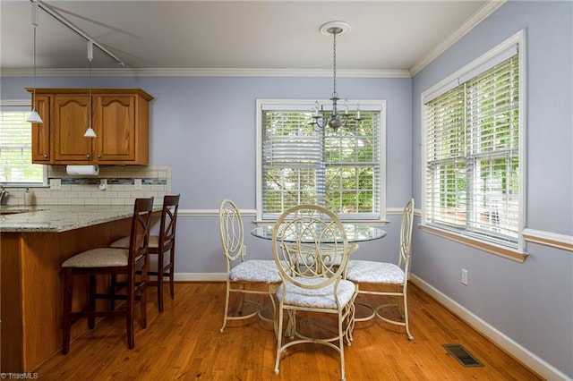 5711 Beaver Pond Trl, Pfafftown, NC 27040 - dining room with light wood-style flooring, baseboards, rail lighting, and crown molding