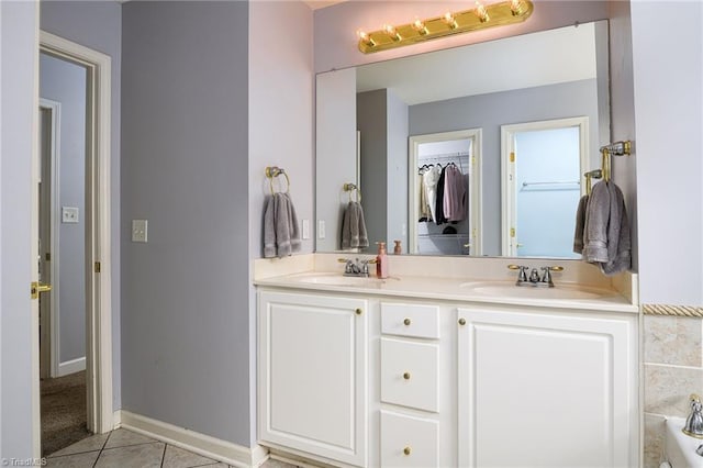 5711 Beaver Pond Trl, Pfafftown, NC 27040 - bathroom with tile patterned floors, double vanity, a walk in closet, and baseboards