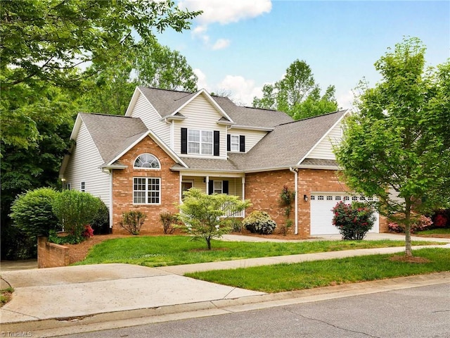5711 Beaver Pond Trl, Pfafftown, NC 27040 - traditional-style house with brick siding, an attached garage, a front yard, and roof with shingles