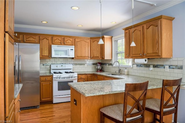 5711 Beaver Pond Trl, Pfafftown, NC 27040 - kitchen featuring white appliances, a sink, a peninsula, brown cabinetry, and light stone counters
