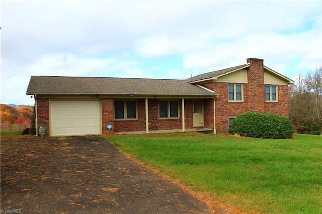 tri-level home with brick siding, an attached garage, driveway, and a front yard